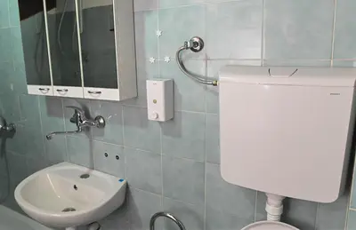 a bathroom with a toilet and a sink and a mirror at Sunset Apartment in Smederevo