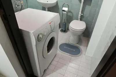 a bathroom with a washing machine and a toilet at Sunset Apartment in Smederevo