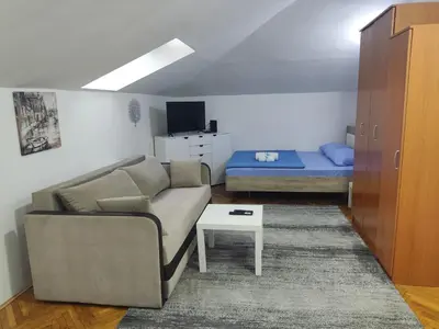 a living room with a couch and a bed at Sunset Apartment in Smederevo