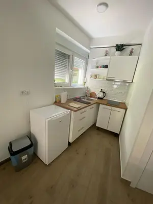 a small kitchen with white cabinets and a wooden floor at ŠTAB 1 City Centre (free parking) Dorćol in Belgrade