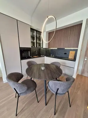 a kitchen with a wooden table and chairs and a table and a counter at Crown Apartments - BW Sole in Belgrade