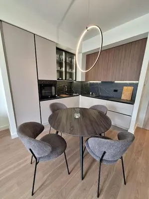 a kitchen with a wooden table and chairs and a table and a mirror at Crown Apartments - BW Sole in Belgrade