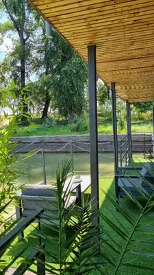 a covered porch with a chair and a table at B&B Botel Charlie in Belgrade