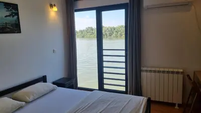 a bedroom with a large window with a view of the water at B&B Botel Charlie in Belgrade