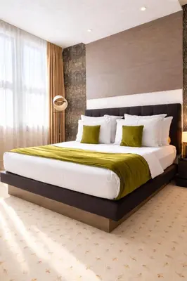 a bedroom with a large bed with a yellow blanket at Atera Business Suites in Belgrade