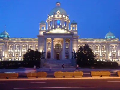 a large white building with a tower with blue lights at Apartment Central in Belgrade