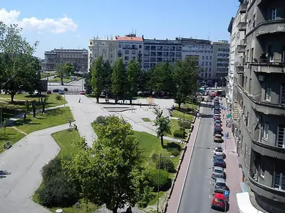 a city street with cars parked in a parking lot at Apartment Central in Belgrade