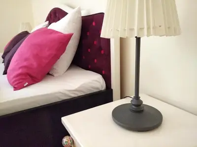 a lamp on a table next to a bed with pillows at Apartment Central in Belgrade