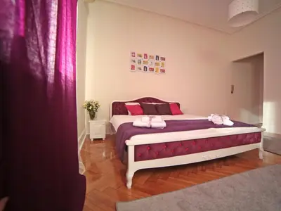 a bedroom with a bed with pink pillows at Apartment Central in Belgrade