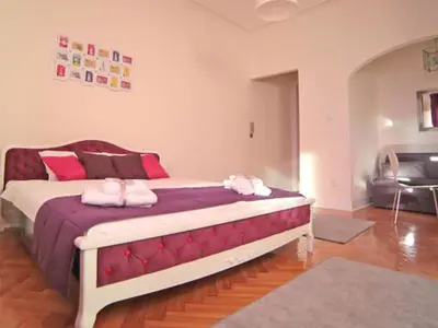 a bedroom with a large bed with pink pillows at Apartment Central in Belgrade