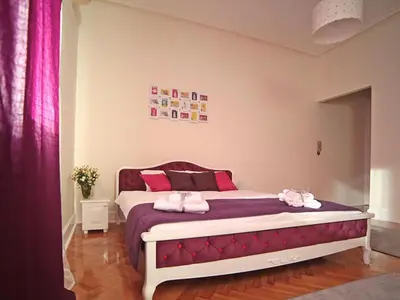 a bedroom with a large bed with pink pillows at Apartment Central in Belgrade