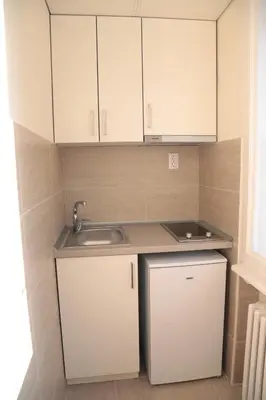 a small kitchen with white cabinets and a sink at Apartment Central in Belgrade