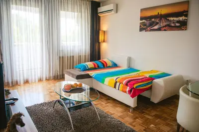 a bedroom with a bed and a glass table at Apartment Arena White in Belgrade