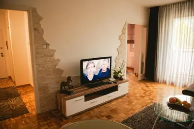 a living room with a flat screen tv on a cabinet at Apartment Arena White in Belgrade