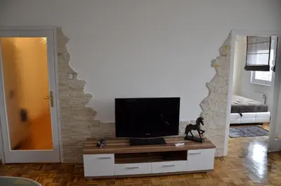 a living room with a flat screen tv on a cabinet at Apartment Arena White in Belgrade