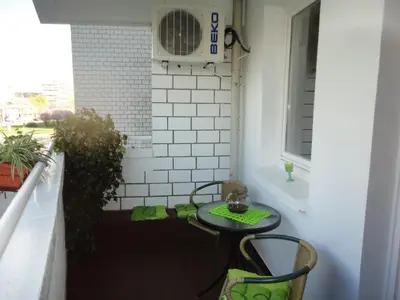 a small patio with a table and chairs and a window at Apartment Arena White in Belgrade