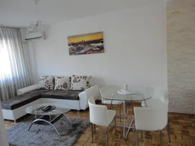 a living room with a couch and a table and chairs at Apartment Arena White in Belgrade