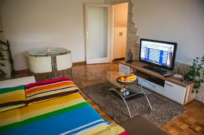 a living room with a colorful couch and a flat screen tv at Apartment Arena White in Belgrade