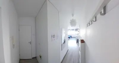 a white room with a hallway with white walls at Cozy studio apartment in Belgrade