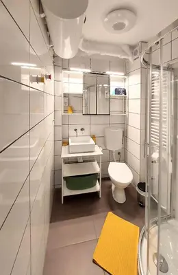 a white bathroom with a sink and a toilet at Cozy studio apartment in Belgrade