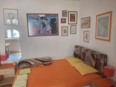 a living room with a bed and some pictures on the wall at Orange Place Studio in Belgrade