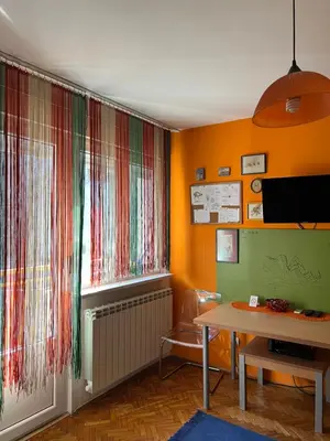 a room with a window with colorful curtains and a table at Orange Place Studio in Belgrade