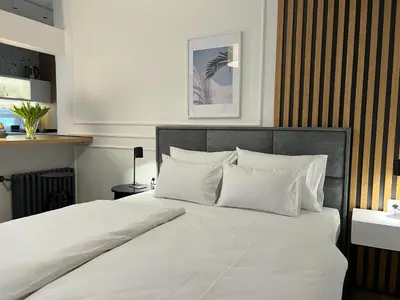 a bedroom with a large bed with white sheets and pillows at RED RIDING HOOD in Belgrade
