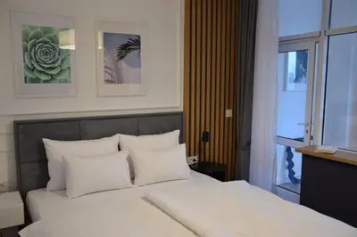 a bedroom with a bed with white pillows and a window at RED RIDING HOOD in Belgrade