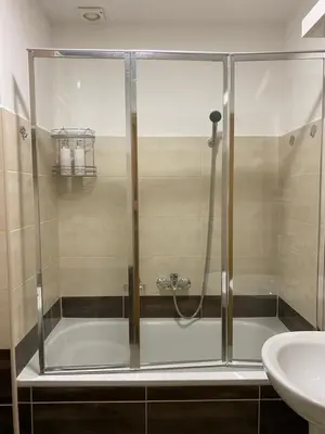 a shower with a glass door next to a sink at Apartman Ljubica in Arandjelovac