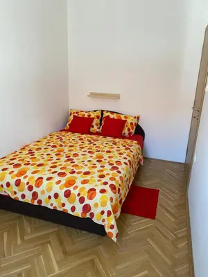 a bedroom with a bed with a colorful comforter at Apartman Ljubica in Arandjelovac