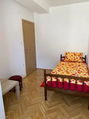 a bedroom with a bed and a wooden floor at Apartman Ljubica in Arandjelovac