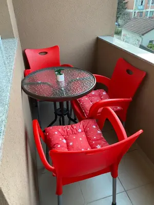 a table with two red chairs and a cup on it at Apartman Ljubica in Arandjelovac