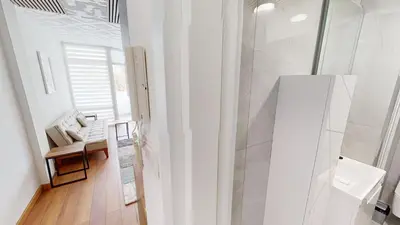 a white bathroom with a chair and a shower at Luka in Belgrade