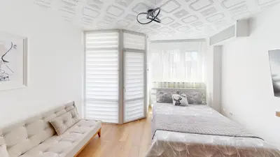 a white bedroom with a bed and a couch at Luka in Belgrade