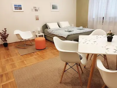 a living room with a bed and a table and chairs at Center Obi-One in Belgrade
