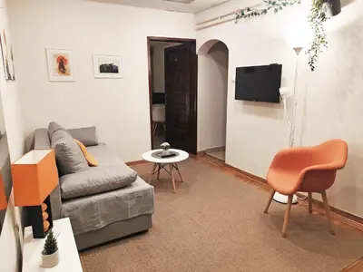 a living room with a couch and a table and a tv at Center Obi-One in Belgrade