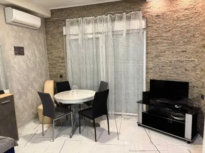 a dining room with a table and a television at Ivet Apartmets in Ledine