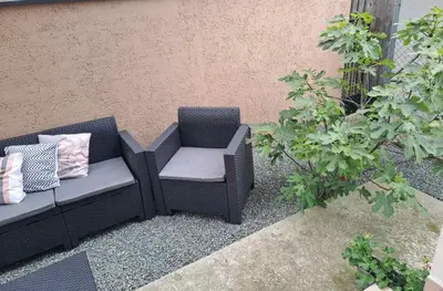 a chair and a couch sitting on a patio at Apartman Ana in Kumodraž