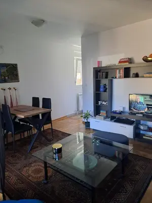 a living room with a glass table and a television at Apartman Ana in Kumodraž