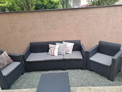 two chairs and a bench with pillows on a patio at Apartman Ana in Kumodraž