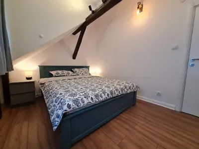 a bedroom with a bed with a blue bed frame at Mansarda, Belgrade in Belgrade