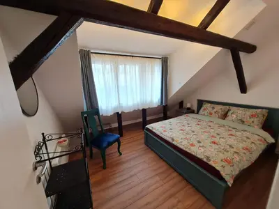 a bedroom with a bed and a blue chair at Mansarda, Belgrade in Belgrade