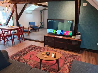 a living room with a flat screen tv and a table at Mansarda, Belgrade in Belgrade