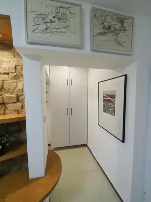a hallway with two white cabinets and a wall with paintings at Galerija MARSHAL in Belgrade