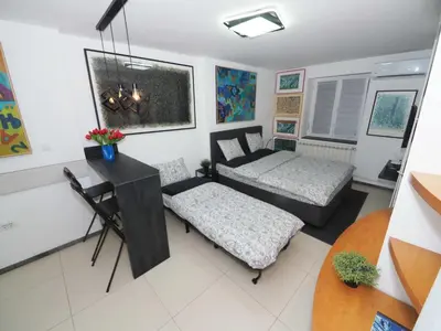 a living room with two beds and a desk at Galerija MARSHAL in Belgrade
