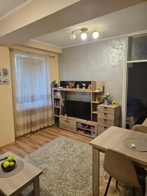 a living room with a large television and a table at Relax 2, sa parkingom in Obrenovac