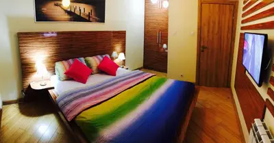 a bedroom with a bed with colorful sheets and pillows at Vip apartment Beograd in Belgrade