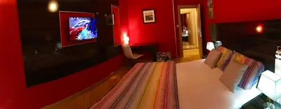a red room with a bed with a rainbow blanket at Vip apartment Beograd in Belgrade
