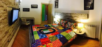 a bedroom with a bed with a colorful quilt on it at Vip apartment Beograd in Belgrade