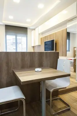 a kitchen with a wooden table and two white chairs at Apartment Barcelona in Belgrade